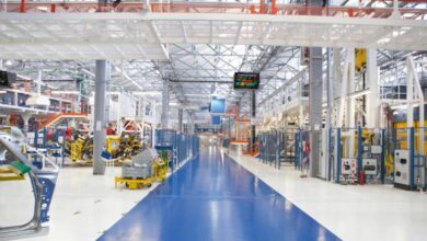 A clean industrial manufacturing floor with a large blue stripe painted on the floor to indicate a passageway.