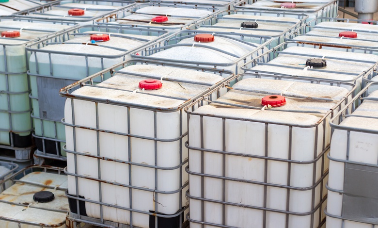 Rows of intermediate bulk containers (IBCs) stacked on top of each other. Metal cage covers each of the containers.